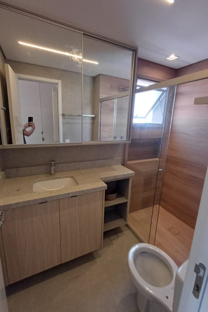 Armário superior de banheiro (espelheira) com portas de abrir, combinando funcionalidade e amplitude visual.