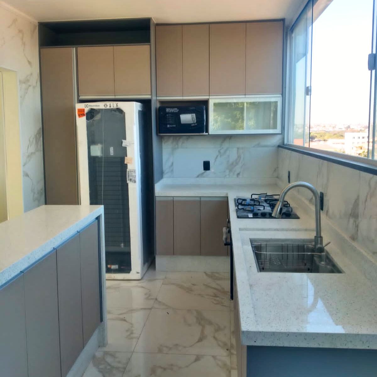 Cozinha planejada para apartamento na Zona Leste, com aproveitamento de canto em L e bancada de granito.