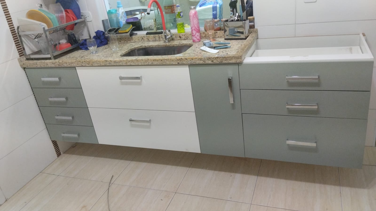 Cozinha gourmet planejada de alto padrão com ilha central, armários brancos e estrutura metálica suspensa (estilo industrial).