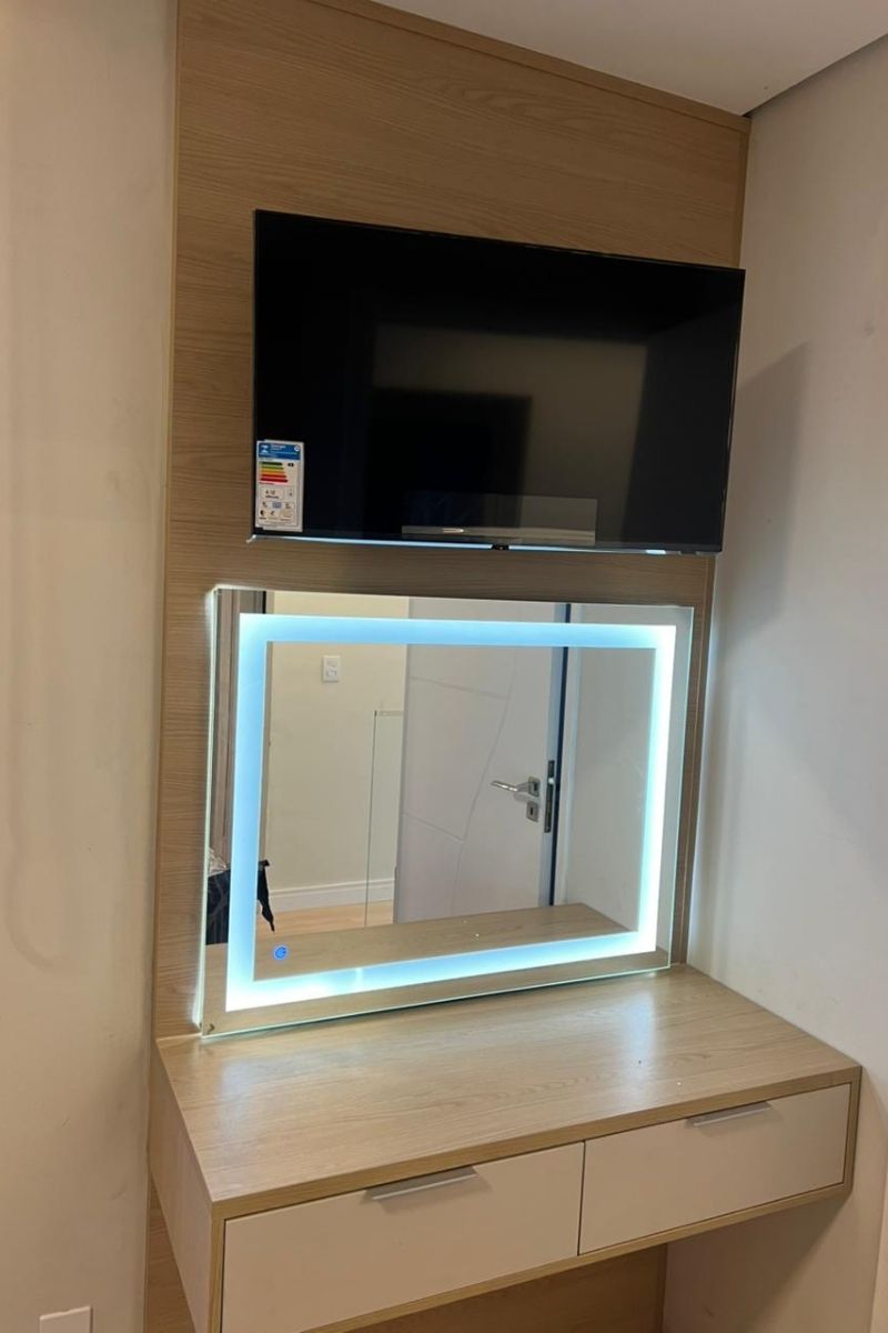 Espelho com iluminação frontal LED (tipo camarim) integrado a móvel planejado branco para clínica ou consultório.