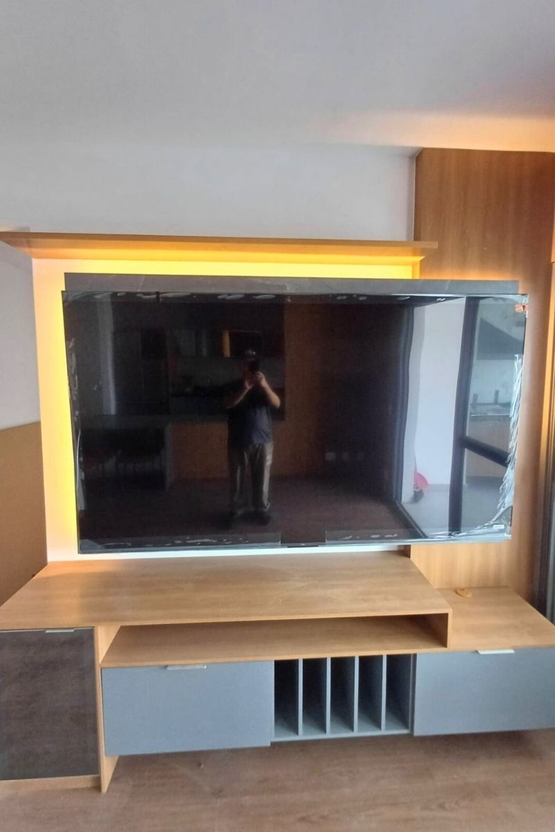 Painel de vidro preto reflexivo ou laca alto brilho para TV, conferindo modernidade e luxo à sala de estar.