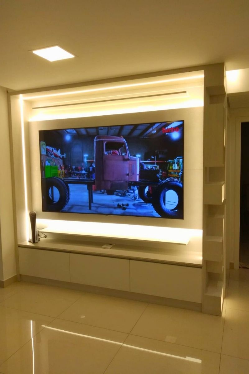 Painel de TV com iluminação LED traseira (efeito cinema), criando um ambiente aconchegante na sala de estar.