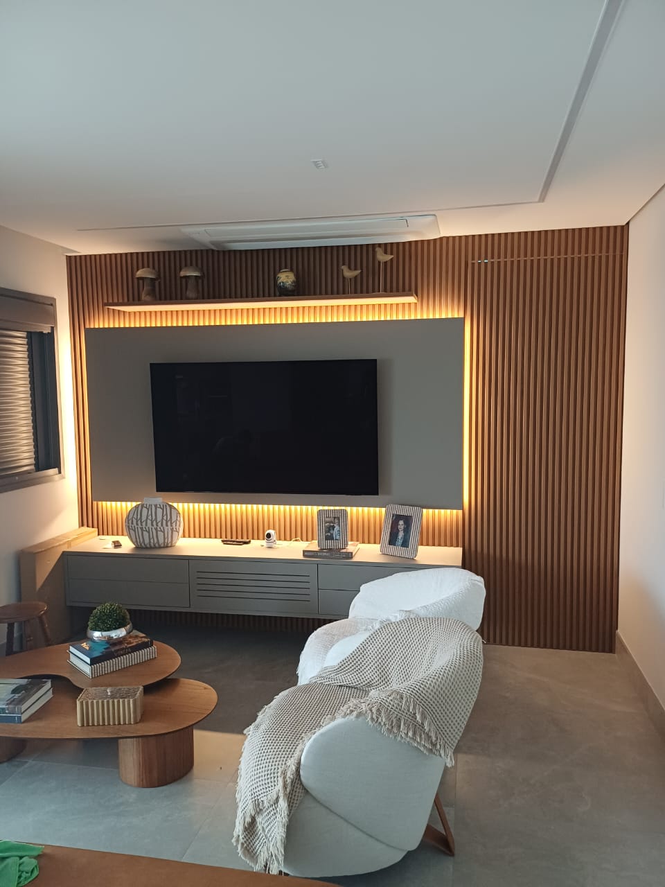 Estrutura de closet ou estante planejada com nichos abertos e gavetas em combinação de cinza e madeira.