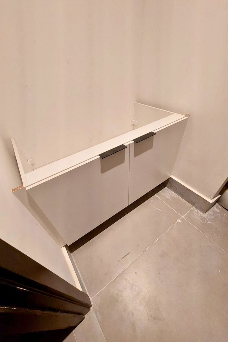 Acabamento de marcenaria em armário branco com puxadores modernos e discretos.