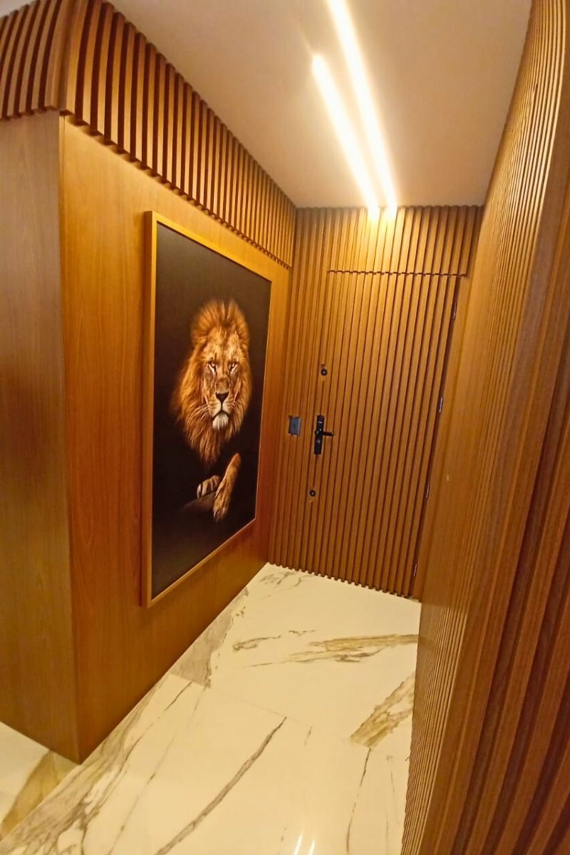 Decoração de interiores com painel ripado de madeira e porta mimetizada para sala de estar.